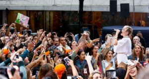 Miley Cyrus performing in front of a cheering crowd